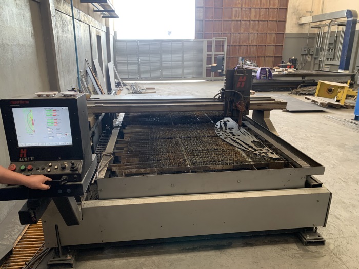 Proceso industrial de corte por plasma CNC sobre placa metálica